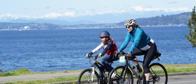 An adult and teen ride past the stunning Puget Sound on the 2025 Ride for Major Taylor