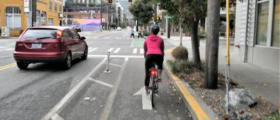 A bicyclist rides in a protected bike lane on 9th Avenue in downtown Seattle