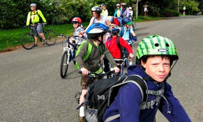Students biking in a line as a "bike train" or "bike bus"
