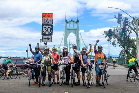 A diverse group of people on bikes celebrate riding STP