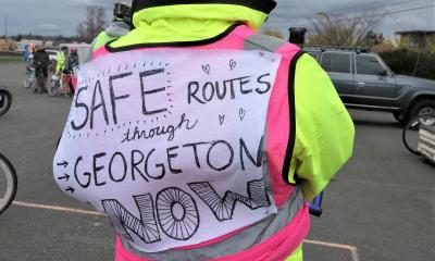 Cyclist with Safe Routes Through Georgetown sign