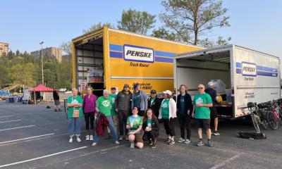 Volunteers post in front of event trucks.