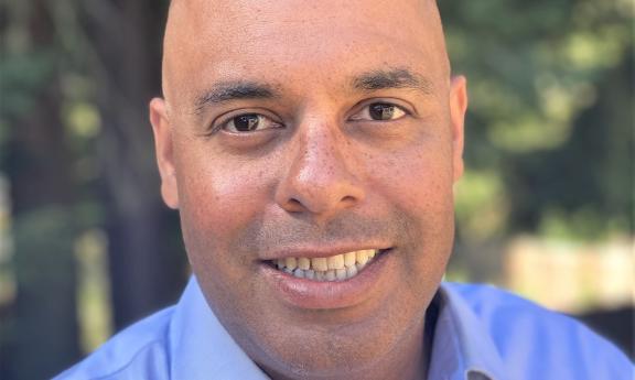A head shot of Lee Lambert in a blue button down.