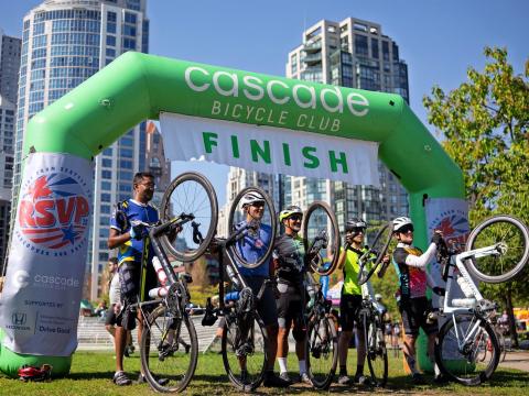 Riders celebrate at the RSVP Finish Line arch in Vancouver, BC.