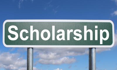 A scholarship sign in front of a blue sky
