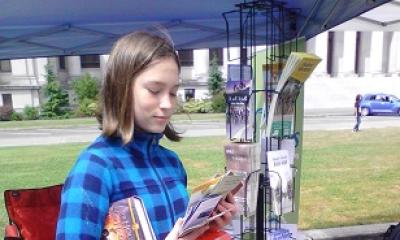 A woman looks at a handful of bike maps
