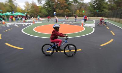 A student bikes around the White Center Traffic Garden, aka Bike Playground