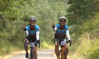Two women give a peace sign while riding STP