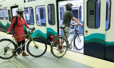 Two cyclists loading their bikes onto the Lightrail