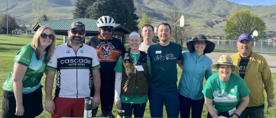 A mixture of volunteers and staff smiling in a field at the start line