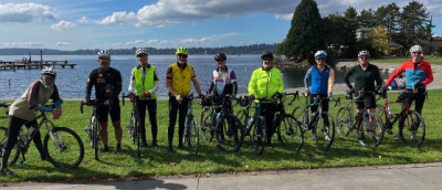 Multiple cyclists standing near Lake Washington
